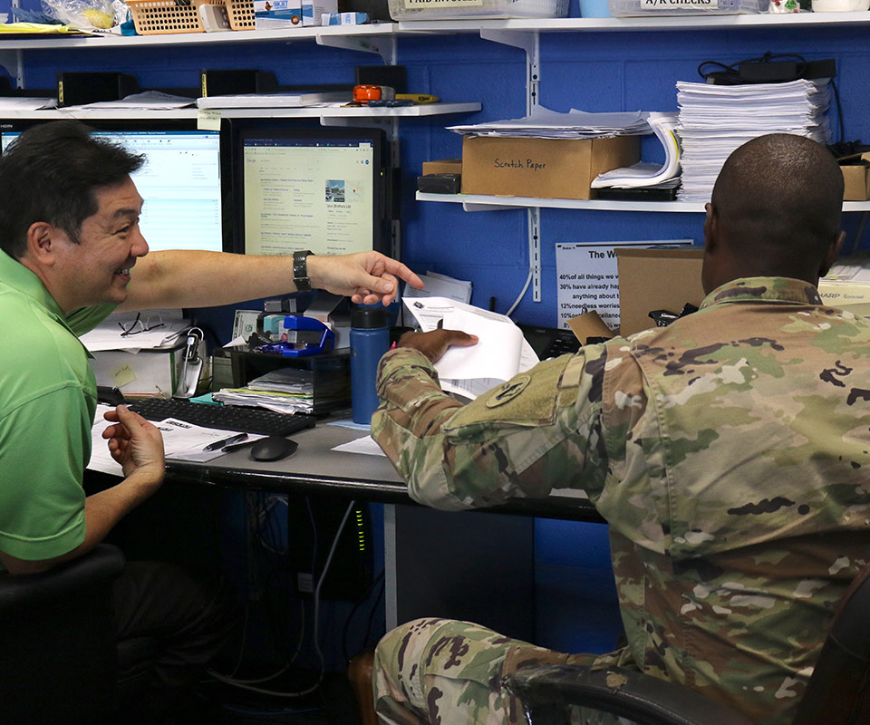 image of printer repair honolulu staff with military person repairing their printer.